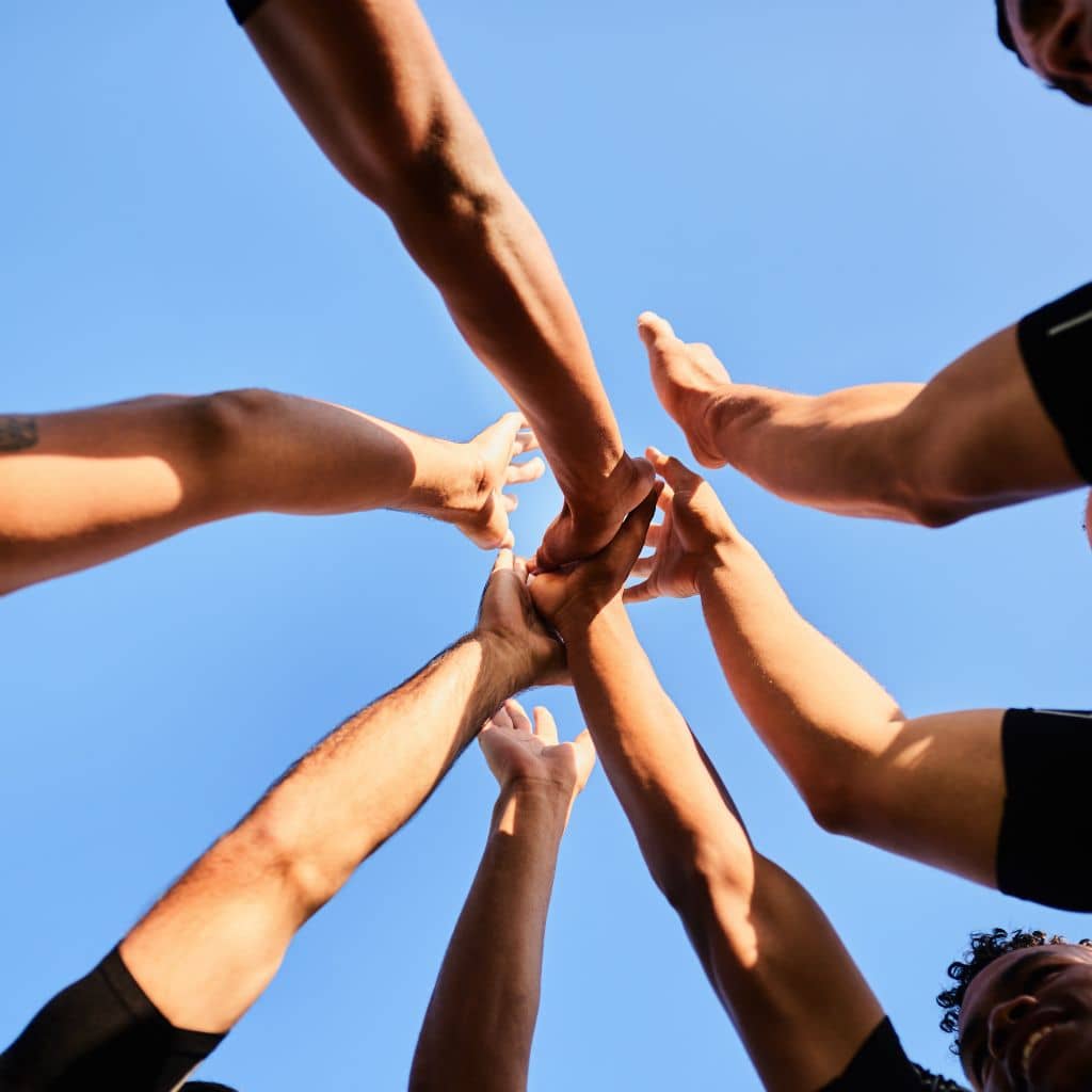 AABJ Enterprises team with all hands in, symbolizing unity and teamwork, indicating our active hiring